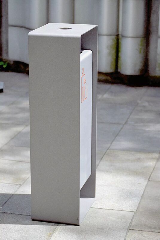 Abfallbehälter RADIUM in RAL 9007 graualuminium und RAL 9006 weißaluminium (zweifarbig auf Anfrage), Siebdruck in RAL 2004 reinorange