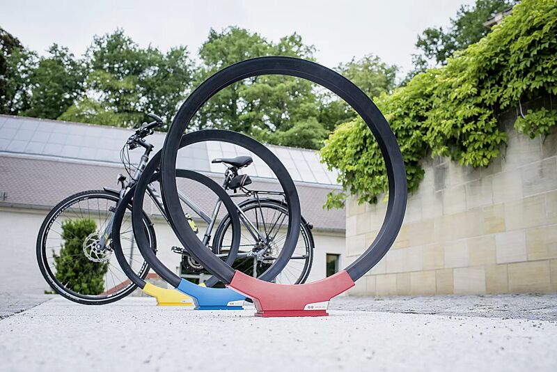 Anlehnbügel GOMEZ, Aluminiumfußabdeckung in RAL 1021 rapsgelb, RAL 5019 capriblau und RAL 3020 verkehrsrot