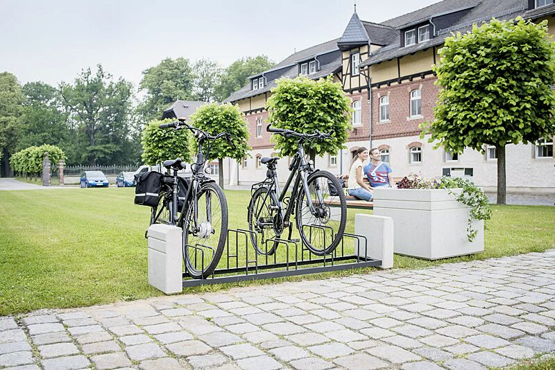 Fahrradständer BRNO, Stahlteile in RAL 7021 schwarzgrau, Beton sandgestrahlt sowie Sitzbank und Pflanzbehälter BRNO