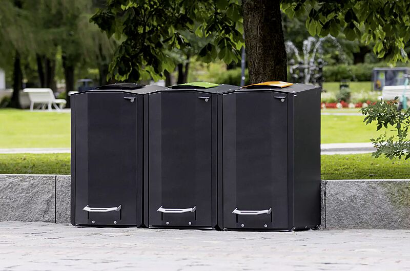 Abfallbehälter EKOCITY, Einwurfklappe in RAL 7021 schwarzgrau, RAL 6018 gelbgrün, RAL 1028 melonengelb, Stahlteile in Finbin Black 1945, ähnl. schwarz metallic, strukturiert