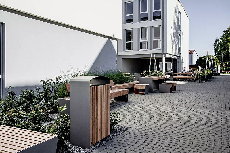 abfallbehaelter-prax__shoKAT0076214 Abfallbehälter PRAX, 120 Liter, Korpus: Jatobaholzbelattung, Stahlteile in RAL 9007 graualuminium, Sitzbank BLOCQ, Tisch BLOCQ (Sonderausführung) und Sitz BLOCQ