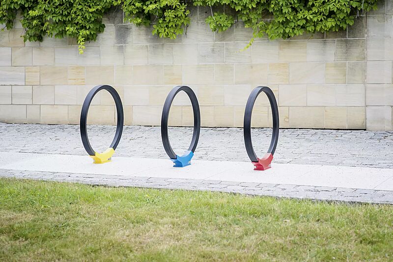 anlehnbuegel-gomez__shoKAT0057829 Anlehnbügel GOMEZ, Aluminiumfußabdeckung in RAL 1021 rapsgelb, RAL 5019 capriblau und RAL 3020 verkehrsrot