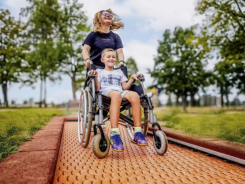 Bodentrampolin RANDI, Umrandung in rot-braun, Sprungmatte ähnlich RAL 2005 leuchtorange