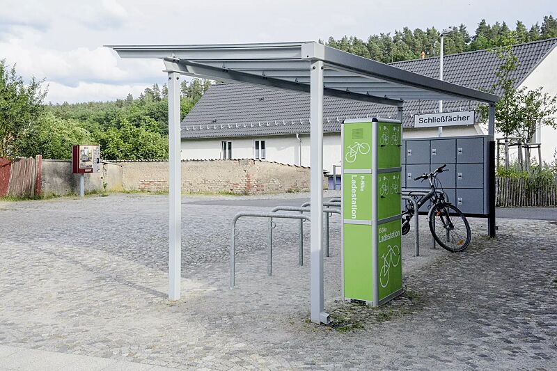 e-bike-ladestellenschrank-amaro__shoKAT0069079 E-Bike-Ladestellenschrank AMARO mit 4 kleinen Ladefächern sowie Fahrradüberdachung PEGASUS, Anlehnbügel MIAMI, Schließfachanlage SECURE