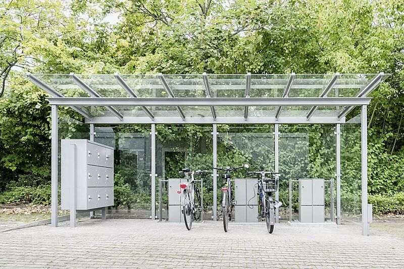 fahrrad-abstellanlage-velo-connector__shoKAT0068231 Fahrrad-Abstellanlage VELO-CONNECTOR, Fahrradüberdachung PEGASUS, Dachbreite x Dachtiefe 6300 mm x 2250 mm, Rück-/Seitenwände ESG, Klarglas, LED- Beleuchtung, Schließfachschrank SECURE, Stahlkonstruktion in RAL 9007 graualuminium
