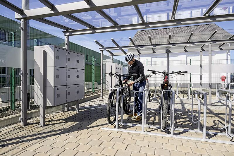 Reihenparker HEDLAND einseitig, hoch / tief, Tiefstellung langer Bügel, zum Aufdübeln bei +/- 0 mm, sowie Fahrradüberdachung PEGASUS und Schließfachanlage SECURE