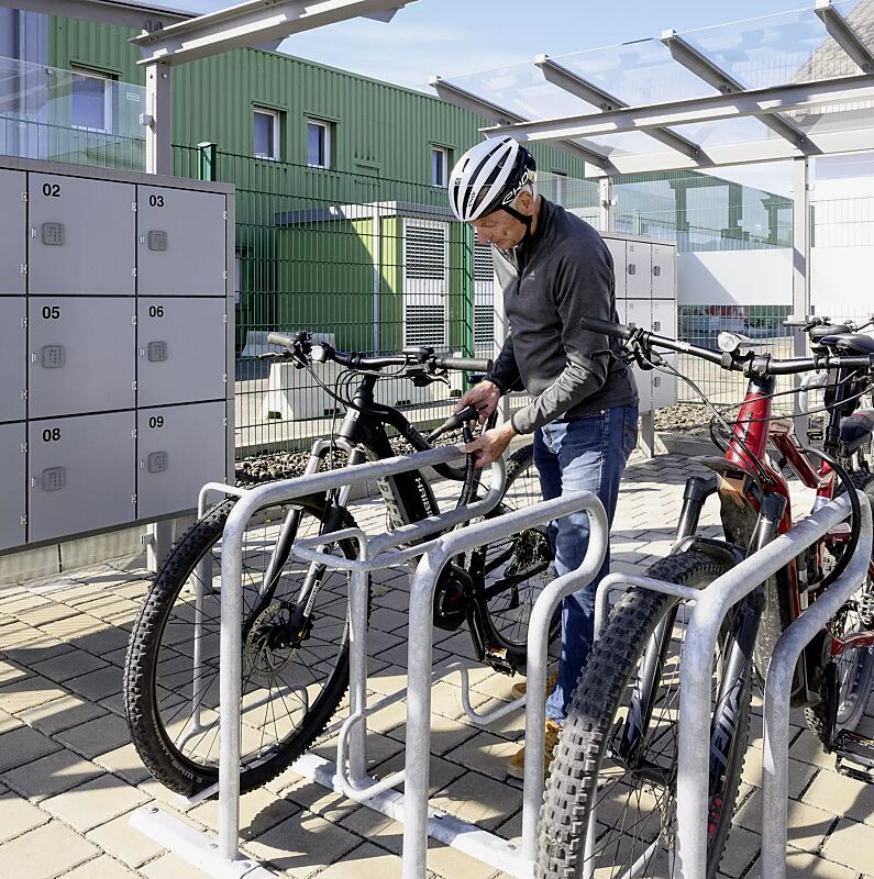 Reihenparker HEDLAND einseitig, hoch / tief, Tiefstellung langer Bügel, zum Aufdübeln bei +/- 0 mm, sowie Fahrradüberdachung PEGASUS und Schließfachanlage SECURE