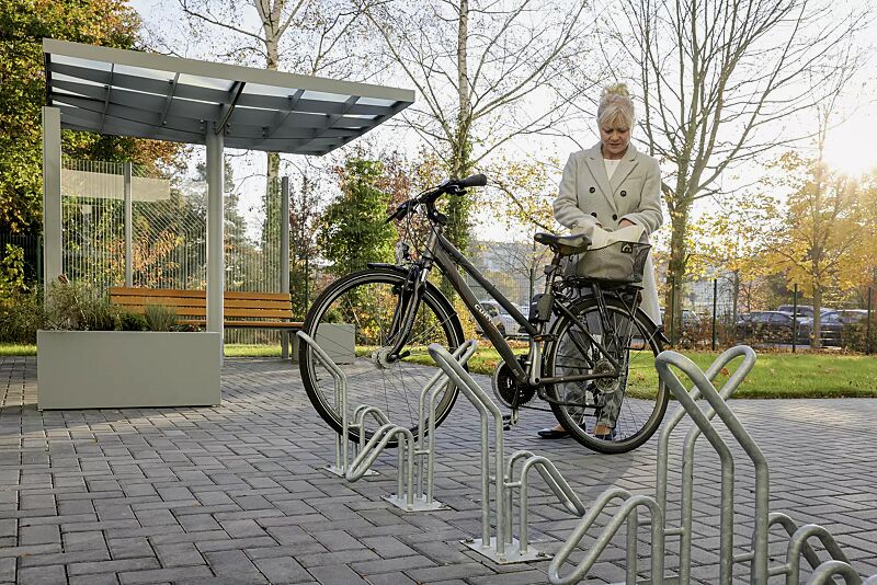 Einzelfahrradständer HERVEY zum Aufdübeln, Meeting-Point PIN, Dachbreite x Dachtiefe 3075 mm x 3075 mm, mit Windschutzwand PIN SCREEN, Sitzbank NATURA, Abfallbehälter LACES, Pflanzbehälter MALOUT, Stahlkonstruktion in RAL 7046 telegrau