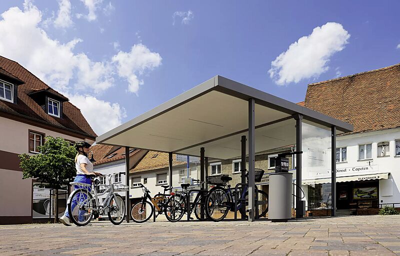 Fahrradüberdachung LUNA, Dachbreite x Dachtiefe 4660 mm x 4800 mm, Mittel- und Seitenwand ESG, Klarglas, Deckenverkleidung mit integrierter LED-Beleuchtung, Sitzbank CARPI, Stahlkonstruktion in DB 702 eisenglimmer