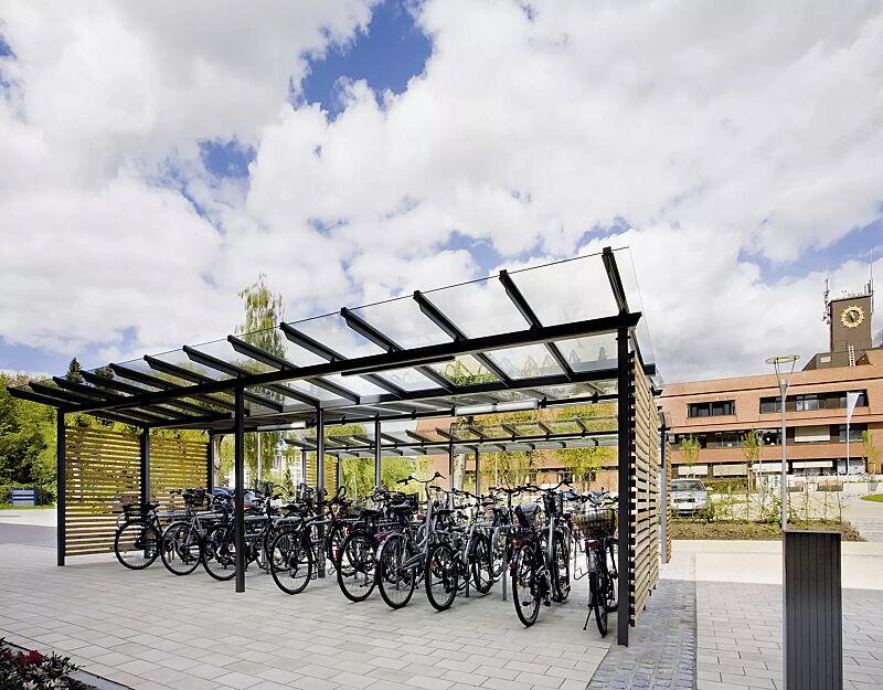 fahrradueberdachung-pegasus__shoKAT0021833 Fahrradüberdachung PEGASUS mit Trogdach, Dachbreite x Dachtiefe 9300 mm x 4500 mm, Seitenwände Holzbelattung Lärche waagerecht, Beleuchtung an den Dachträgern, Stahlkonstruktion in DB 703 eisenglimmer