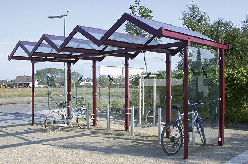 Fahrradüberdachung TANGENTA, einseitig, auftragsbezogene Anpassung mit Unterzug aufgrund erhöhter Schneelast, Dachbreite x Dachtiefe 6200 mm x 2250 mm, Rück- / Seitenwände ESG, Klarglas mit Raubvogelaufkleber, Stahlkonstruktion in RAL 4002 rotviolett