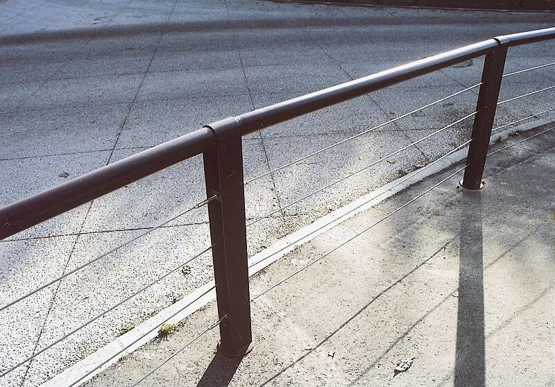 Systemgeländer CYDLIMIT bestehend aus Mittelpoller mit Edelstahldrähten und Verbindungsrohren, in RAL 7022 umbragrau