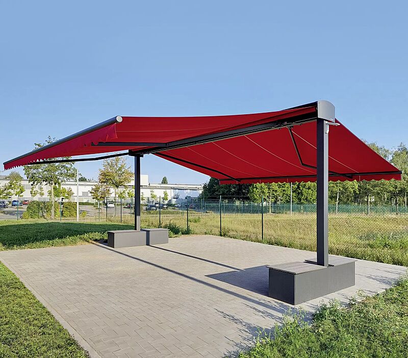 Markisenfreigestell VOLANTIS, zweiseitige Ausführung, Markisenbreite 5000 mm, Markisentuch in 5890 verkehrsrot (UPF 50+), Beschwerungskästen mit WPC-Sitzauflage, Aluminiumkonstruktion in RAL 7016 anthrazitgrau