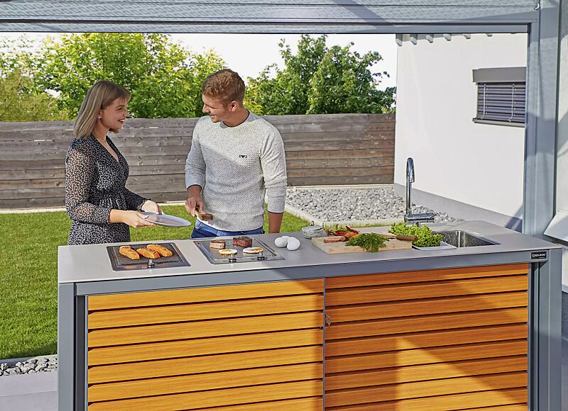 outdoor-kueche-cookout-linis__shoKAT0066439 Outdoor-Küche COOKOUT® LINIS, auftragsbezogene Anpassung mit Ausschnitt für zwei bauseitige Grills, Aluminiumkonstruktion in RAL 7035 lichtgrau, Türlamellen in Holzdekor Douglasie