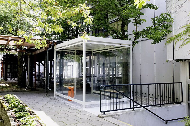 Raucherunterstand AQUILA mit auftragsbezogener Anpassung (seitlicher Zugang), Dachbreite x Dachtiefe 3180 mm x 2165 mm, mit Rück- / Seitenwänden sowie Windschutzwand, Stahlkonstruktion in RAL 9002 grauweiß