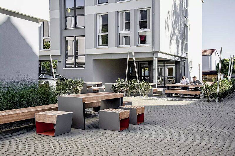 sitz-blocq__shoKAT0076217 Sitz BLOCQ mit Jatobaholzbelattung, Stahlteile in bicolour (Sonderausführung in RAL 9007 graualuminium und RAL 3020 verkehrsrot), Sitzbank BLOCQ und Tisch BLOCQ (Sonderausführung)