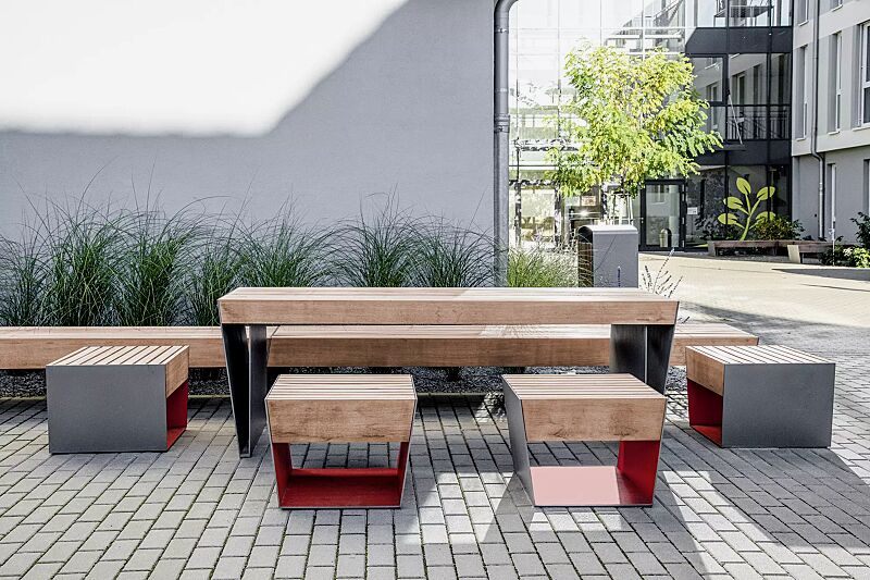 sitz-blocq__shoKAT0076218 Sitz BLOCQ mit Jatobaholzbelattung, Stahlteile in bicolour (Sonderausführung in RAL 9007 graualuminium und RAL 3020 verkehrsrot), Sitzbank BLOCQ, Tisch BLOCQ (Sonderausführung) und Abfallbehälter PRAX