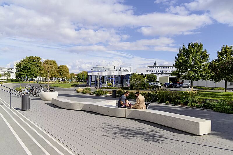 sitzbank-kubb__shoKAT0075393 Sitzbank KUBB bestehend aus CROSS KUBB, CURVED KUBB und DOUBLE KUBB, aus Beton, Sitzfläche geschliffen, in Granitoptik weiß sowie Pflanzbehälter GIOVE, Anlehnbügel ELK und Abfallbehälter CIMA