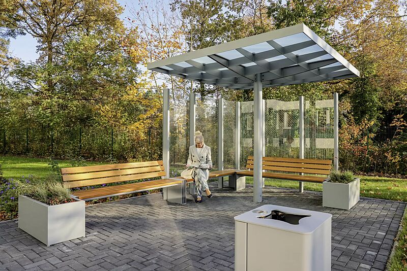 Sitzbank NATURA mit und ohne Rückenlehne, mit Eschenholzbelattung, Windschutzwand PIN SCREEN, Meeting-Point PIN, Abfallbehälter LACES, Pflanzbehälter MALOUT, Stahlkonstruktion in RAL 7046 telegrau