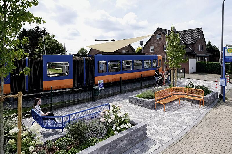 Eckbank RIMINI (Typ ML) mit Rückenlehne, zum Einbetonieren, in RAL 2003 pastellorange und RAL 5010 enzianblau sowie Abfallbehälter KÖLN ohne Ascher, 35 Liter, mit Lochoptik, zum Einbetonieren, in RAL 6005 moosgrün