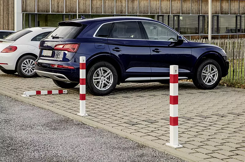Sperrpfosten GERNIKA NEW zum Aufdübeln, einseitig kippbar, mit Bodenplatte, mit Profilzylinderschloss, in RAL 9010 reinweiß mit roten Reflexstreifen