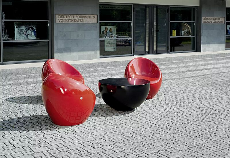 Tisch FAMILY zum freien Aufstellen, aus Beton, in RAL 9005 tiefschwarz und Sitz CUDDLY aus Beton, zum freien Aufstellen, in RAL 3000 feuerrot