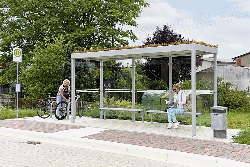 Wartehalle GEMALA GREEN, Dachbreite x Dachtiefe 4600 mm x 1600 mm, mit Rück- / Seitenwänden ESG, Klarglas, Sitzbank VOLTERRA, Abfallbehälter HALIFAX, Stahlkonstruktion in RAL 9006 weißaluminium