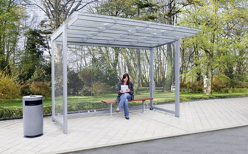 Wartehalle PICTOR, Dachbreite x Dachtiefe 3500 mm x 2250 mm (auftragsbezogene Anpassung), Rück- / Seitenwände ESG, Klarglas, Sitzbank TOBACCO, Abfallbehälter CIMA, Stahlkonstruktion in DB 701 eisenglimmer