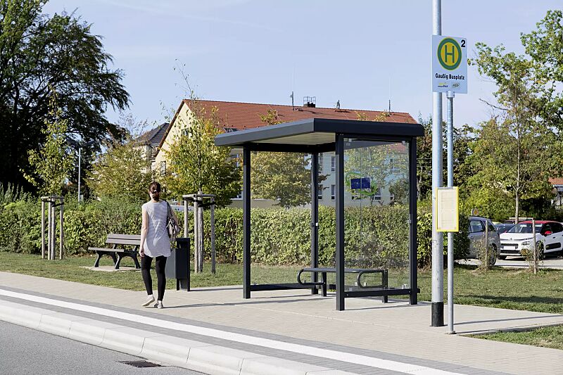 wartehalle-stadt__shoKAT0058410 Wartehalle STADT, Dachbreite x Dachtiefe 2520 mm x 1800 mm, mit Rück- / Seitenwänden ESG, Klarglas, Sitzbank SESTO, Abfallbehälter HALIFAX, Stahlkonstruktion in RAL 7021 schwarzgrau