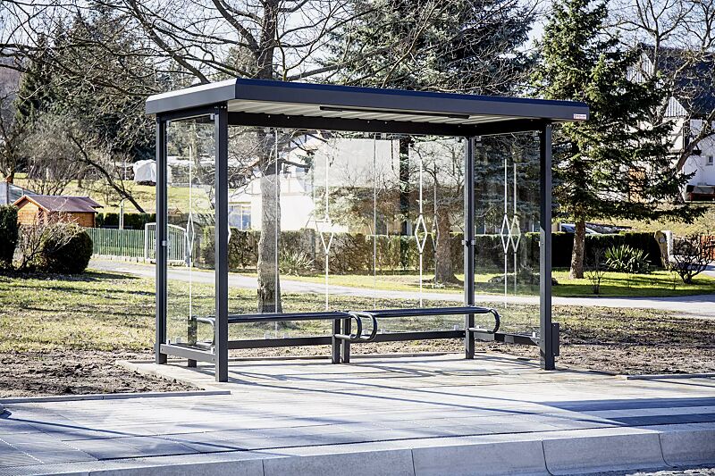 wartehalle-stadt__shoKAT0073798 Wartehalle STADT, Dachbreite x Dachtiefe 3620 mm x 1800 mm, Rück- und Seitenwände ESG, Klarglas mit Siebdruckdekor Raute, Sitzbank SESTO, LED-Beleuchtung, Stahlkonstruktion in RAL 7021 schwarzgrau